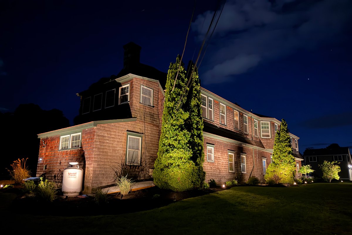 Full property landscape lighting installation at night, cedar shingle home in Rhode Island